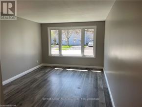 London North (North F) multi-family for rent - A room with a window showing a view of a street with cars and buildings.