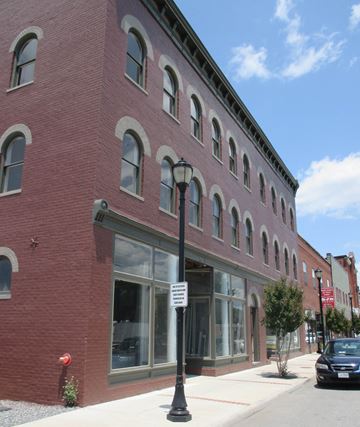 Radford apartment for rent - A red brick building with a black car parked in front.