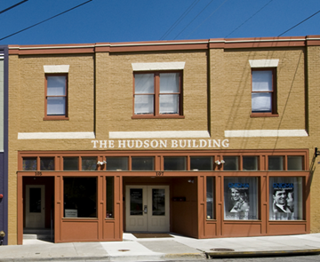 Radford apartment for rent - The Hudson Building is a two-story brick building with a flat roof and a sign on the front.