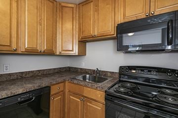 Lake Hiawatha apartment for rent - a kitchen with a stove sink and microwave and wooden cabinets