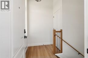 Amherstburg apartment for rent - A hallway with a wooden railing and white walls.