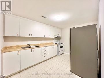 Toronto (Centennial Scarborough) apartment for rent - A kitchen with white cabinets and a sink.
