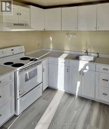 Ajax (Central) apartment for rent - A kitchen with white cabinets and a stove top oven.