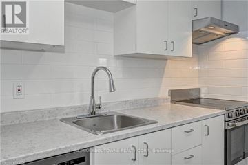 Kitchener condo for rent - A modern kitchen with a stainless steel sink and white cabinets.