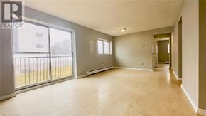 Kitchener condo for rent - A spacious room with a sliding glass door leading to a balcony.