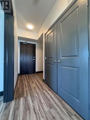 Strathroy-Caradoc (Mount Brydges) townhouse for rent - A hallway with wood flooring and blue doors.