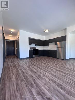 Strathroy-Caradoc (Mount Brydges) townhouse for rent - A modern kitchen with dark wood flooring and stainless steel appliances.