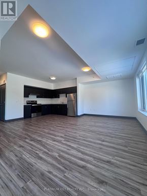 Strathroy-Caradoc (Mount Brydges) townhouse for rent - A room with wooden flooring and a white ceiling.