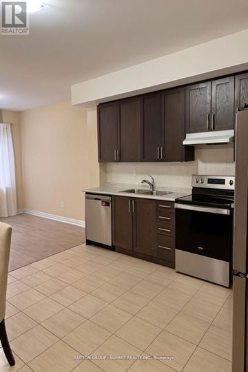 Oshawa (Central) triplex for rent - A kitchen with brown cabinets and stainless steel appliances.