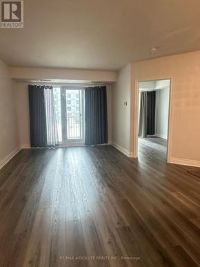 Ottawa condo for rent - A room with wooden flooring and a window with curtains.