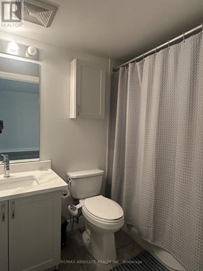 Ottawa condo for rent - A white toilet sits next to a sink in a small bathroom.
