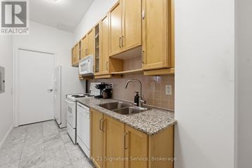 Toronto (Willowdale East) condo for rent - A kitchen with wooden cabinets and a granite countertop.