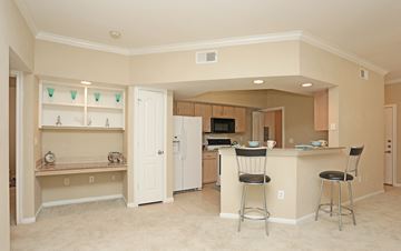 Katy apartment for rent - A kitchen with white cabinets and a white fridge.
