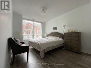 Markham (Commerce Valley) condo for rent - A bedroom with a bed, nightstand, and chair.