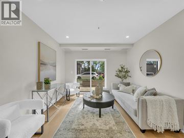 Windsor apartment for rent - A modern living room with a glass coffee table and a large window.