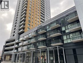 Kitchener condo for rent - A modern building with a glass facade and a sign that reads "REALTOR".