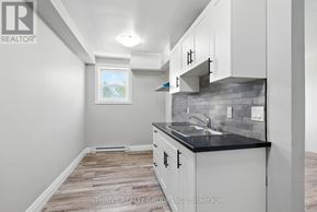 London East (East K) multi-family for rent - A kitchen with white cabinets and a black countertop.