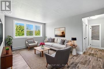 London East (East K) multi-family for rent - A living room with a couch, chair, and a table with a lamp on it.