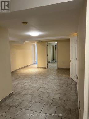 Brampton (Bramalea North Industrial) apartment for rent - A hallway with tiled flooring and white walls.
