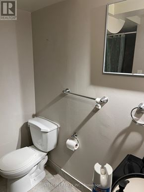 Brampton (Bramalea North Industrial) apartment for rent - A white toilet in a bathroom with a mirror above it.