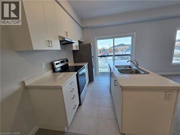 Hamilton townhouse for rent - A kitchen with white cabinets and a black oven.