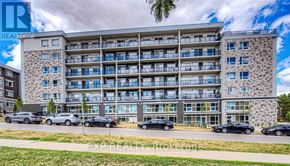 Waterloo condo for rent - A large apartment building with cars parked in front.