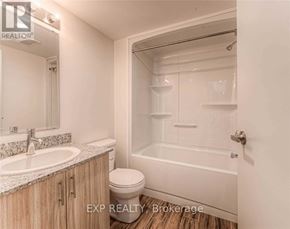 Waterloo condo for rent - A bathroom with a toilet, sink, and bathtub.