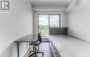 Waterloo condo for rent - A bedroom with a bed, desk, and chair is shown.