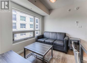 Waterloo condo for rent - A living room with a black leather couch and a wooden coffee table.