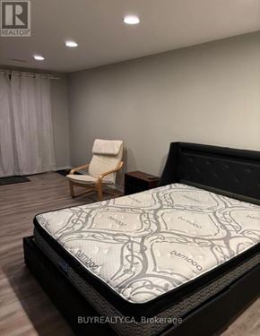 Aurora (Aurora Grove) apartment for rent - A bed with a Serta mattress is in a room with a chair.