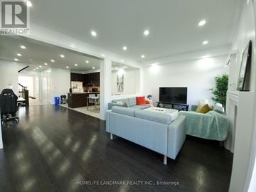 Brampton (Sandringham-Wellington) townhouse for rent - A spacious living room with a grey sofa and a television.
