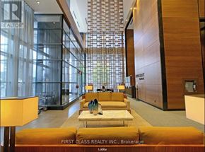 Toronto (Willowdale East) condo for rent - A lobby with a yellow couch and a glass wall.
