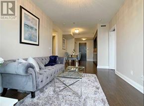 Toronto (Willowdale East) condo for rent - A living room with a grey couch and a glass coffee table.