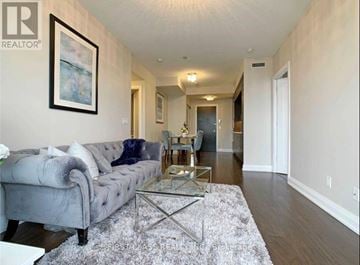 Toronto (Willowdale East) condo for rent - A living room with a grey couch and a glass coffee table.