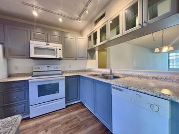 Davie apartment for rent - A kitchen with a white oven and microwave, a white sink, and a white dishwasher.