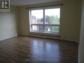 Ottawa condo for rent - A room with a large window and wooden flooring.