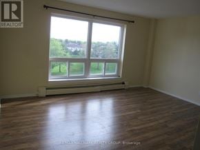 Ottawa condo for rent - A room with a large window and wooden flooring.