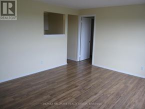 Ottawa condo for rent - A room with wooden flooring and a door on the right side.