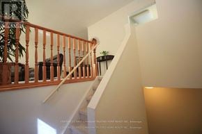 London North (North I) apartment for rent - A staircase with a wooden railing and a potted plant on top.