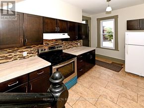 Ottawa apartment for rent - A kitchen with brown cabinets and a white refrigerator.