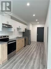 Guelph (Willow West/Sugarbush/West Acres) condo for rent - A modern kitchen with wooden cabinets and stainless steel appliances.