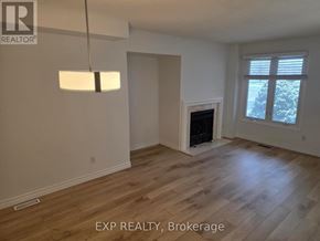 Oakville (Cv Clearview) apartment for rent - A room with a fireplace and a window with a view of trees.