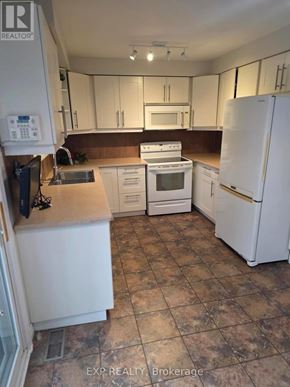 Oakville (Cv Clearview) apartment for rent - A kitchen with white appliances and brown countertops.