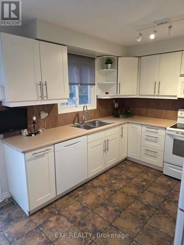 Oakville (Cv Clearview) apartment for rent - A kitchen with white cabinets and brown countertops.