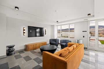 Kelowna apartment for rent - A living room with a brown couch and a black table.