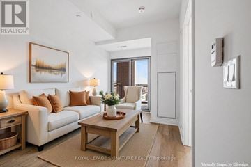 Clarington (Bowmanville) condo for rent - A well-lit living room with a couch, coffee table, and a painting on the wall.