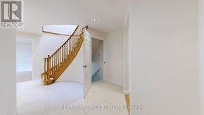 Toronto (Agincourt South-Malvern West) apartment for rent - A spacious room with a wooden staircase leading to another room.