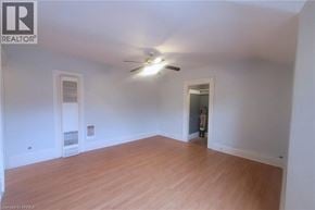 Brantford apartment for rent - A room with wooden floors and white walls, with a ceiling fan and two doors.