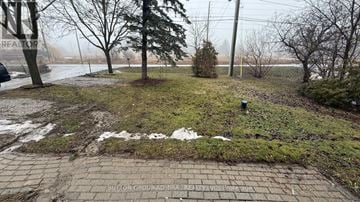 Richmond Hill apartment for rent - A brick pathway leads through a grassy area with trees and a foggy background.
