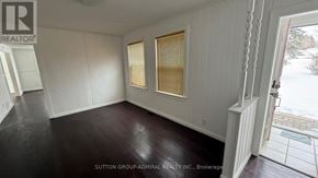 Richmond Hill apartment for rent - A room with white walls and dark flooring is shown.